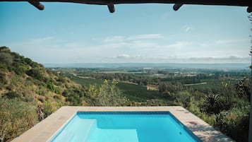 A swimming pool with a view of a hilly landscape.