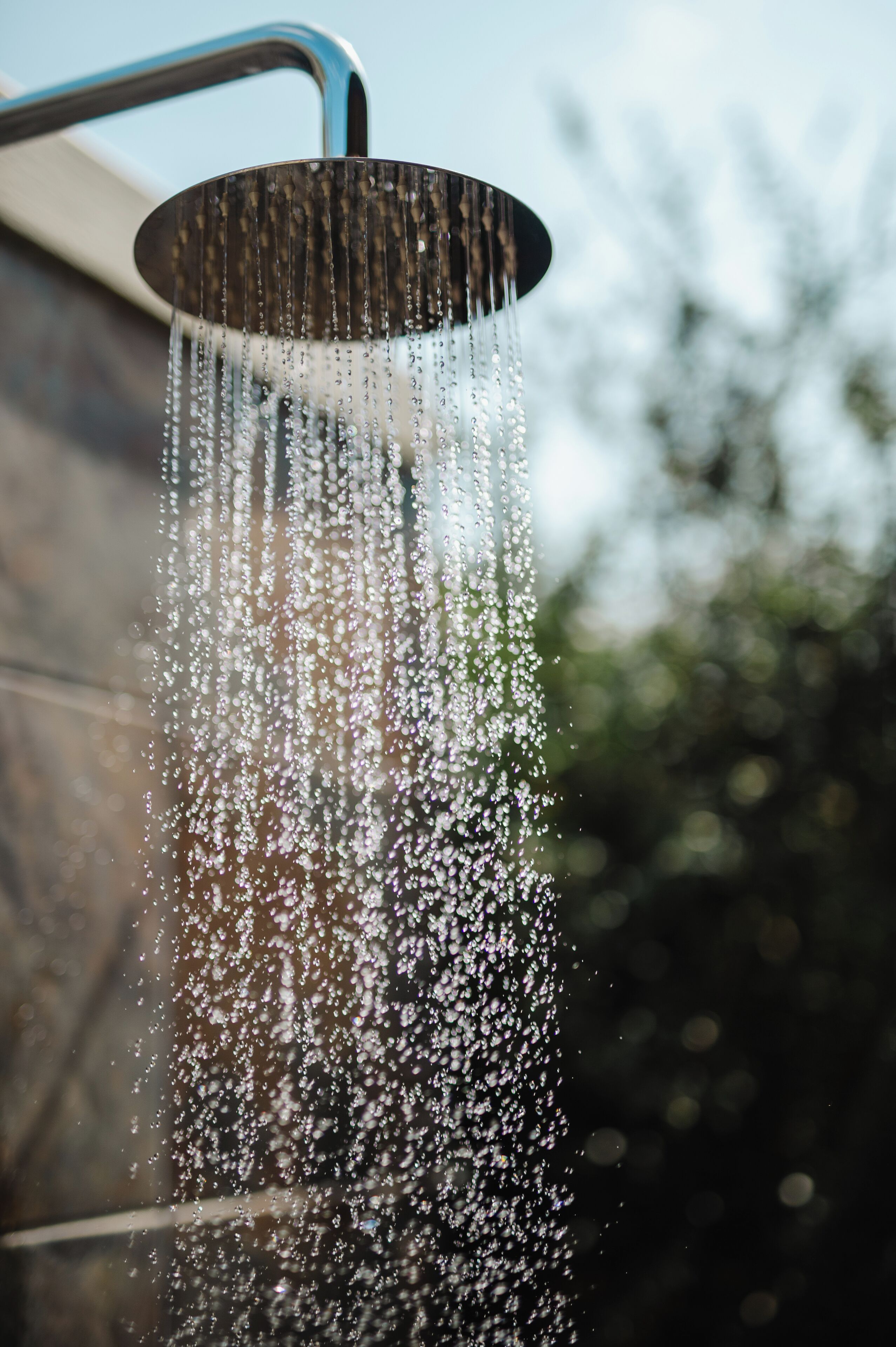 Un pommeau de douche laissant couler l’eau.