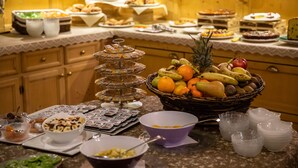 A buffet with various food items and a fruit basket. - Hotel Amerikan (Livigno)