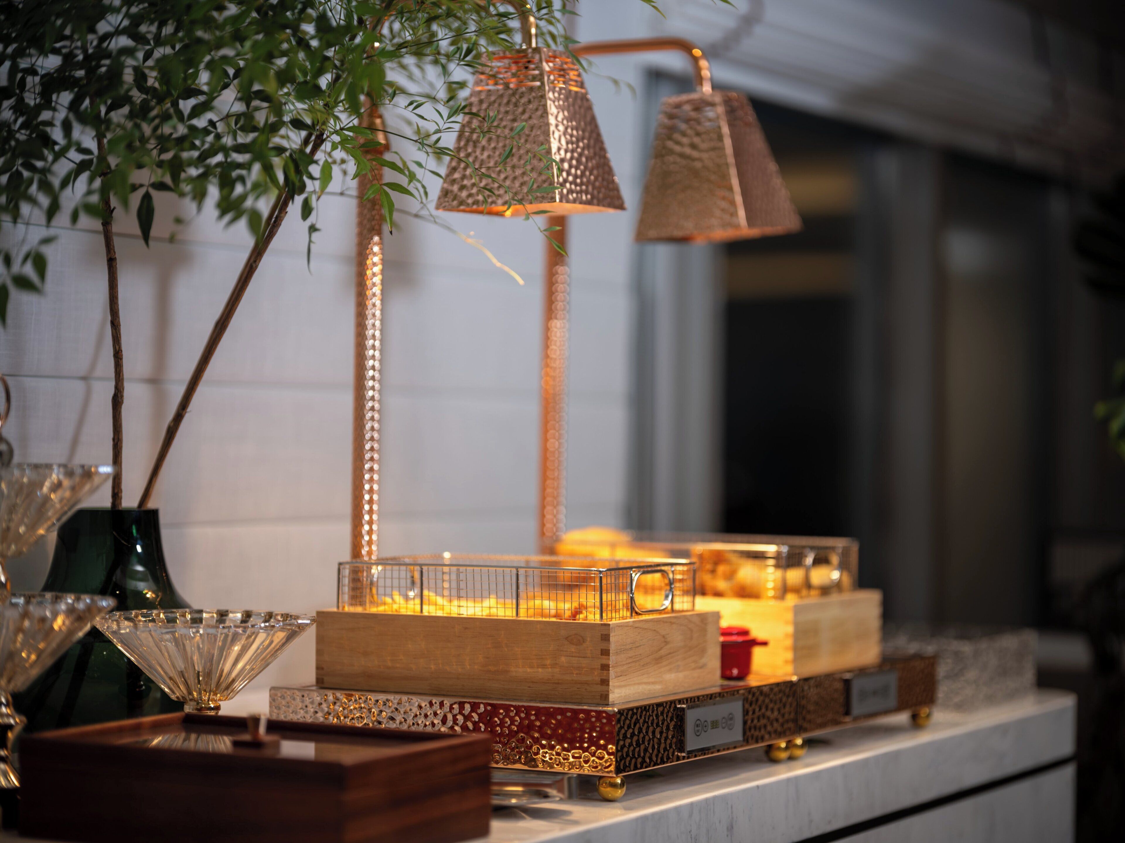 A display of decorative items including a lamp, a glass bowl, and a wooden box with a nameplate.