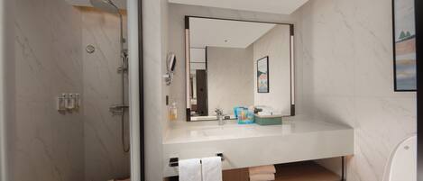 A modern bathroom with a shower, toilet, and sink.