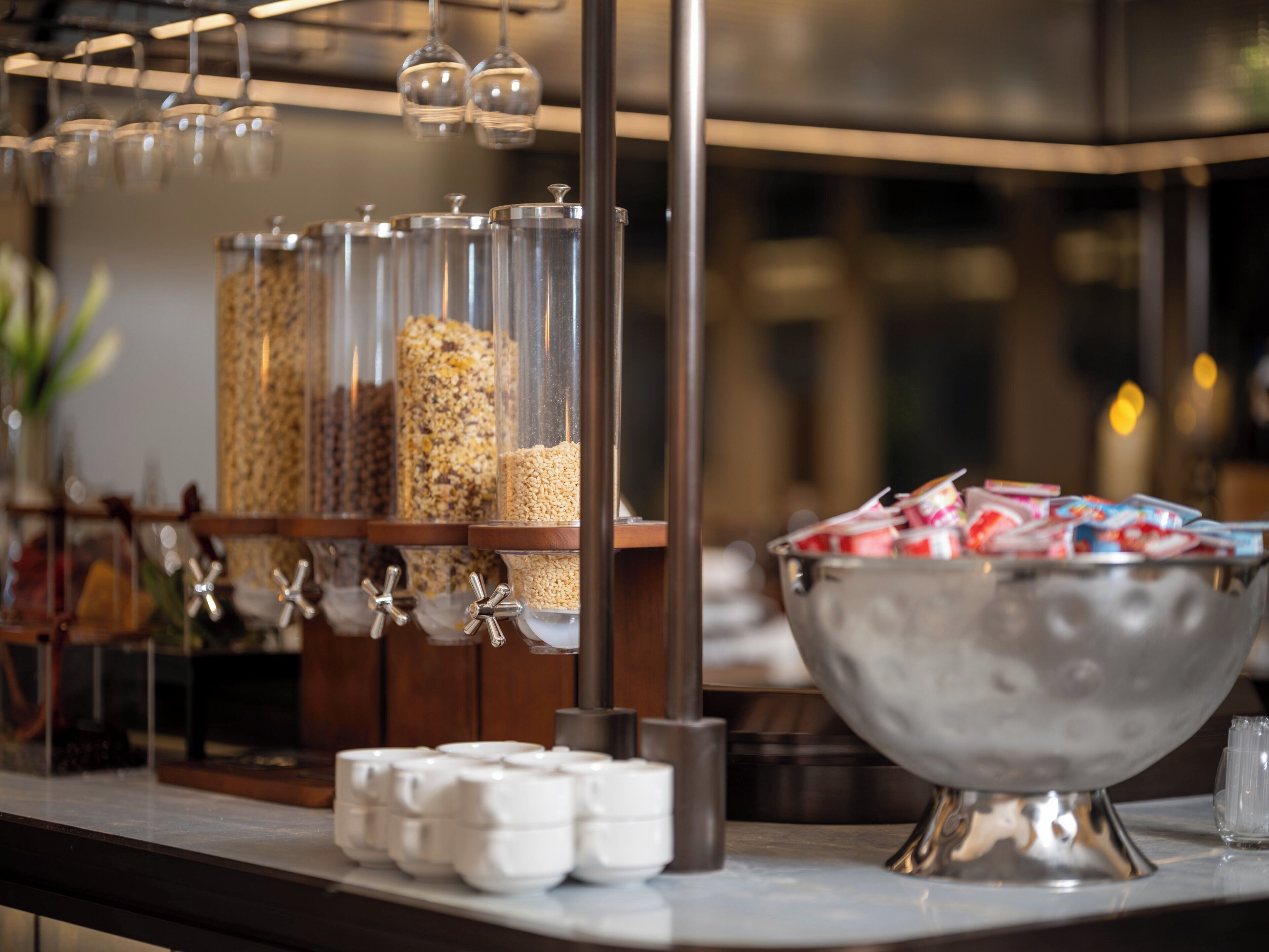 A buffet area with various food containers and a bowl of snacks.