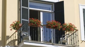 A building with a balcony, a window with shutters, and a sign above the window. - Hotel Villa Maria (Ischia)