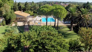 Una propiedad residencial con piscina, terraza cubierta y vistas del paisaje circundante.