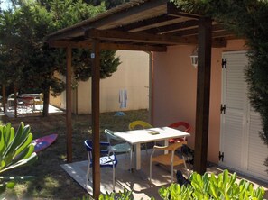 An outdoor patio with a table and chairs, surrounded by greenery and a wooden pergola. - VVF Sigean Port-la-Nouvelle Corbières (Sigean)
