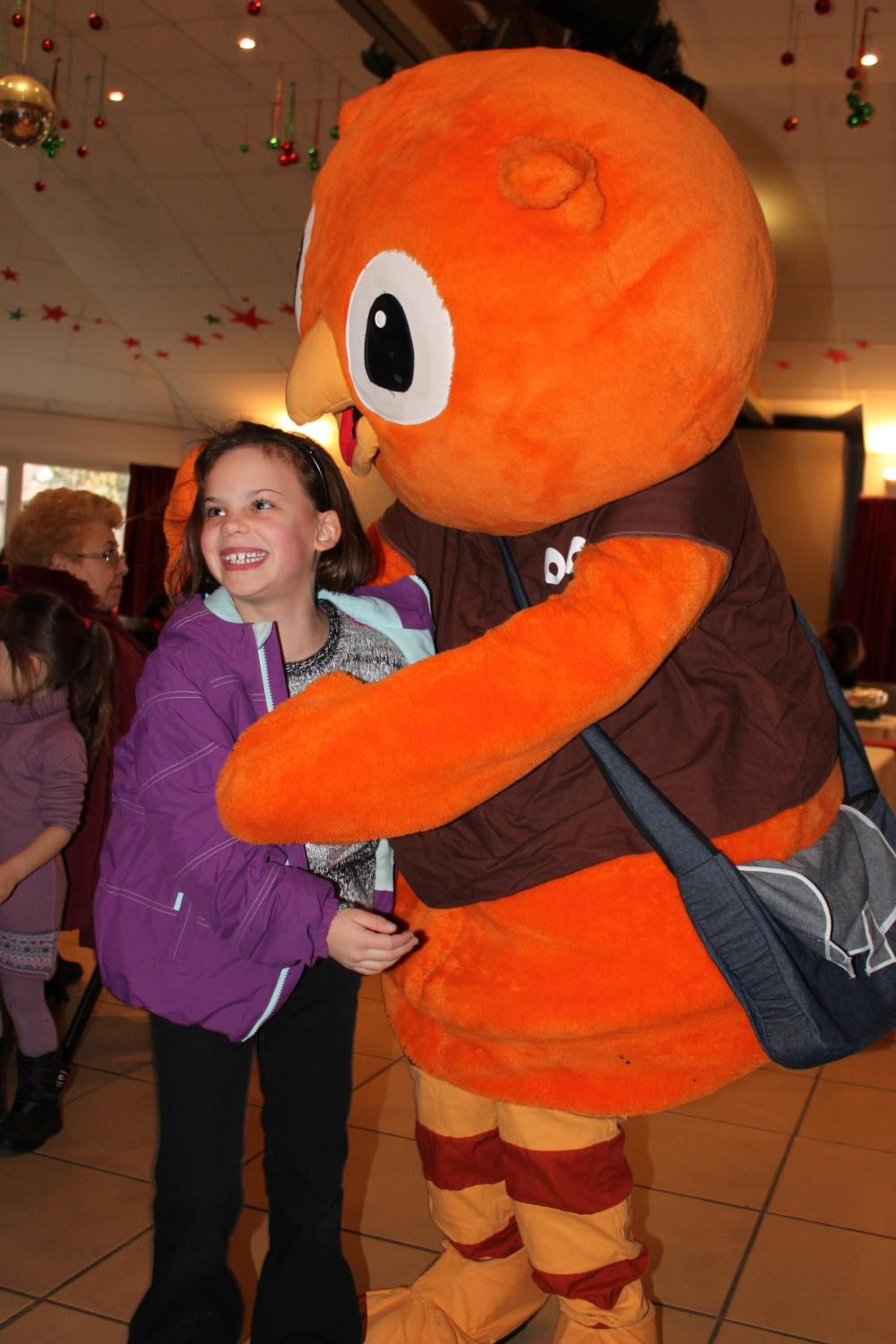 A person in a large orange mascot costume.
