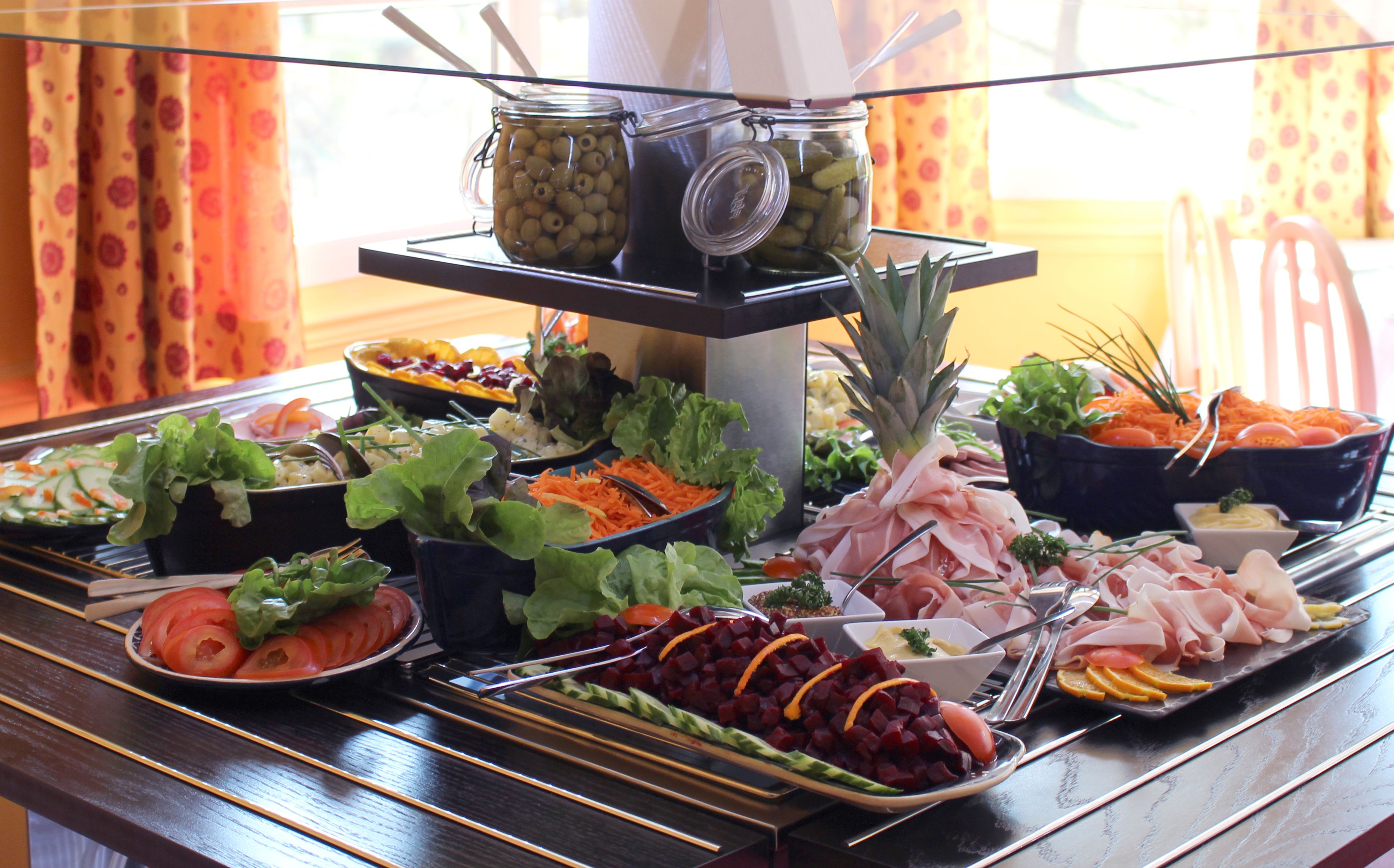 A buffet table with various food items and condiments.