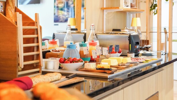 A breakfast buffet with various food items and a coffee machine.