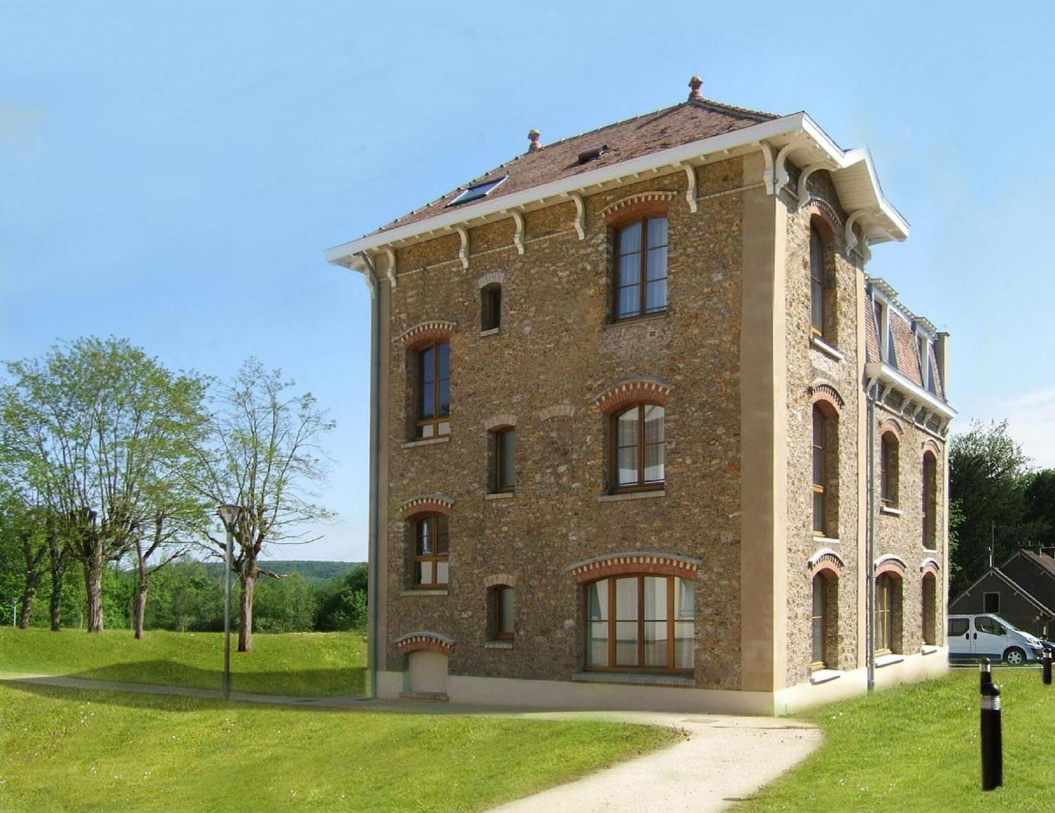 A stone building with multiple windows and a central entrance.