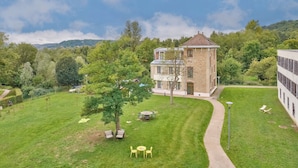A large building with a tower, surrounded by a well-maintained lawn and trees.