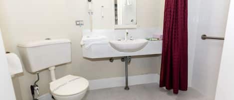 Un baño pequeño con inodoro, lavamanos y espejo.