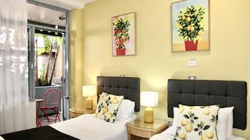 A hotel room with two beds, a red chair, and two wall-mounted lamps.
