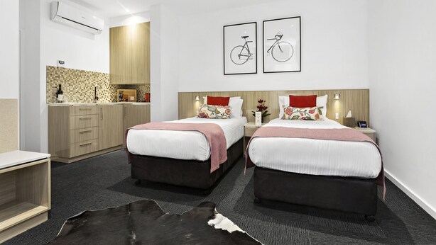 A hotel room with two beds, a small desk, a kitchenette, and a large mirror. - North Adelaide Boutique Stays Accommodation (North Adelaide)
