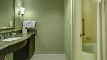 Casa de banho com duas pias, um espelho, porta-toalhas e zona de duche.