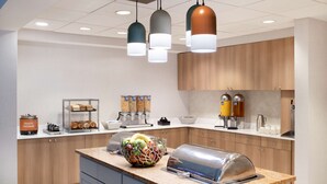 A modern kitchen with a granite countertop, a coffee station, and a fruit bowl. - Homewood Suites West Palm Beach (West Palm Beach)