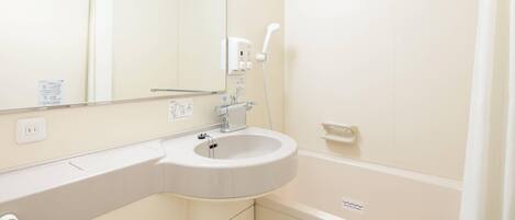 A bathroom with a white sink, mirror, and bathtub.