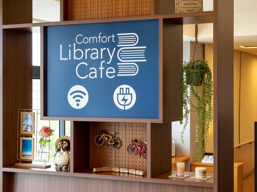 Señal de un café Comfort Library con íconos para Wi-Fi y carga de vehículos eléctricos.