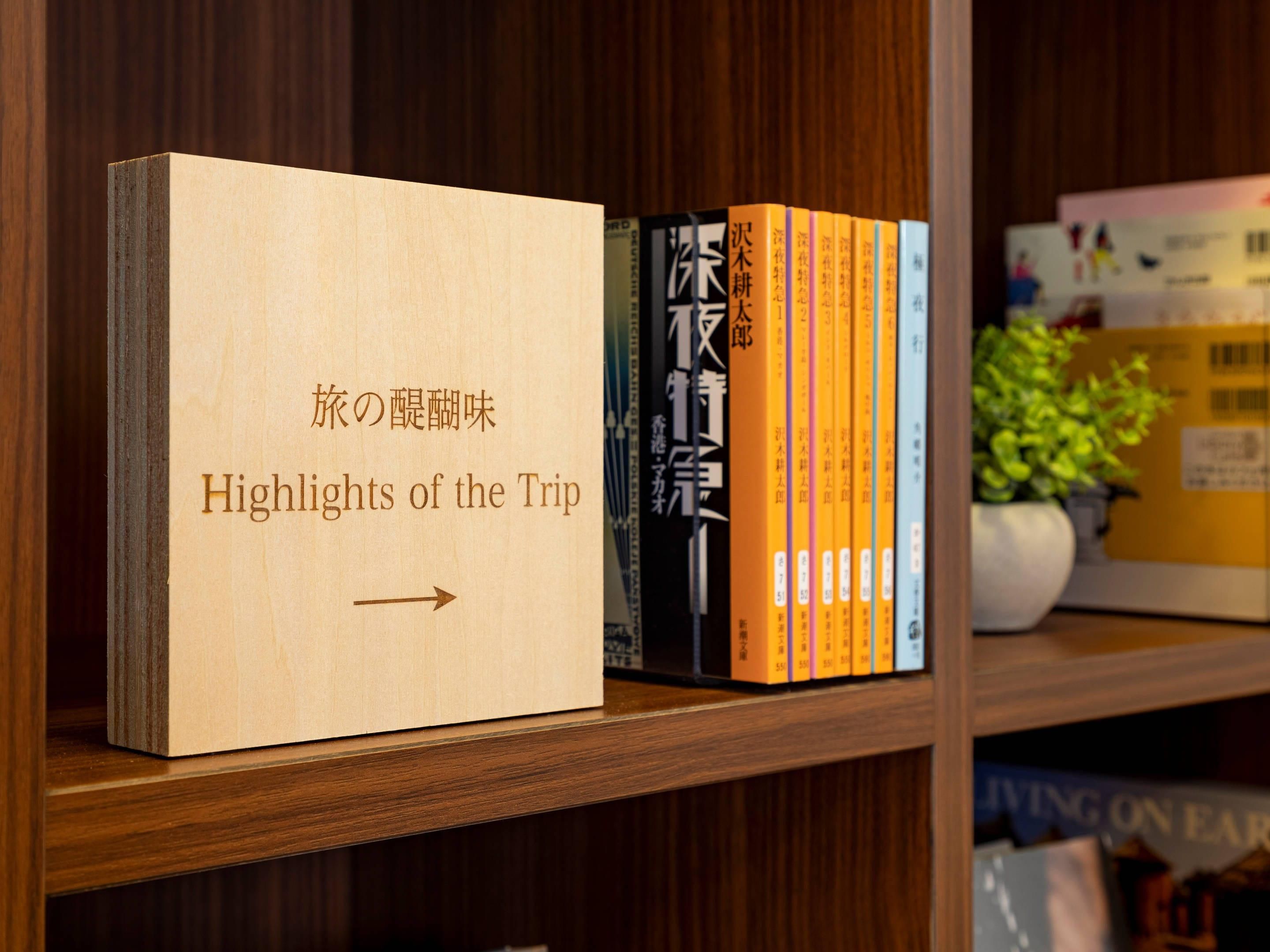 A bookshelf with a book titled "Highlights of the Trip" and several other books in various languages.