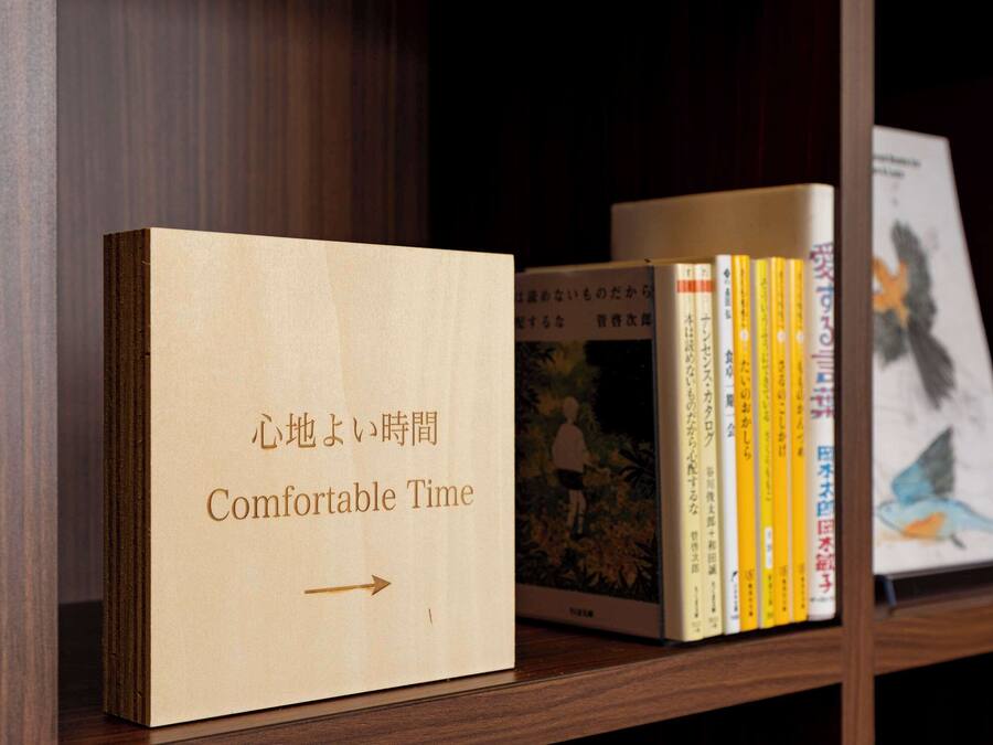 Ein Bücherregal mit einem Buch mit dem Titel 'Comfortable Time' und mehreren anderen Büchern.