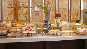 Un bufé con diversos alimentos y una planta decorativa en el centro.