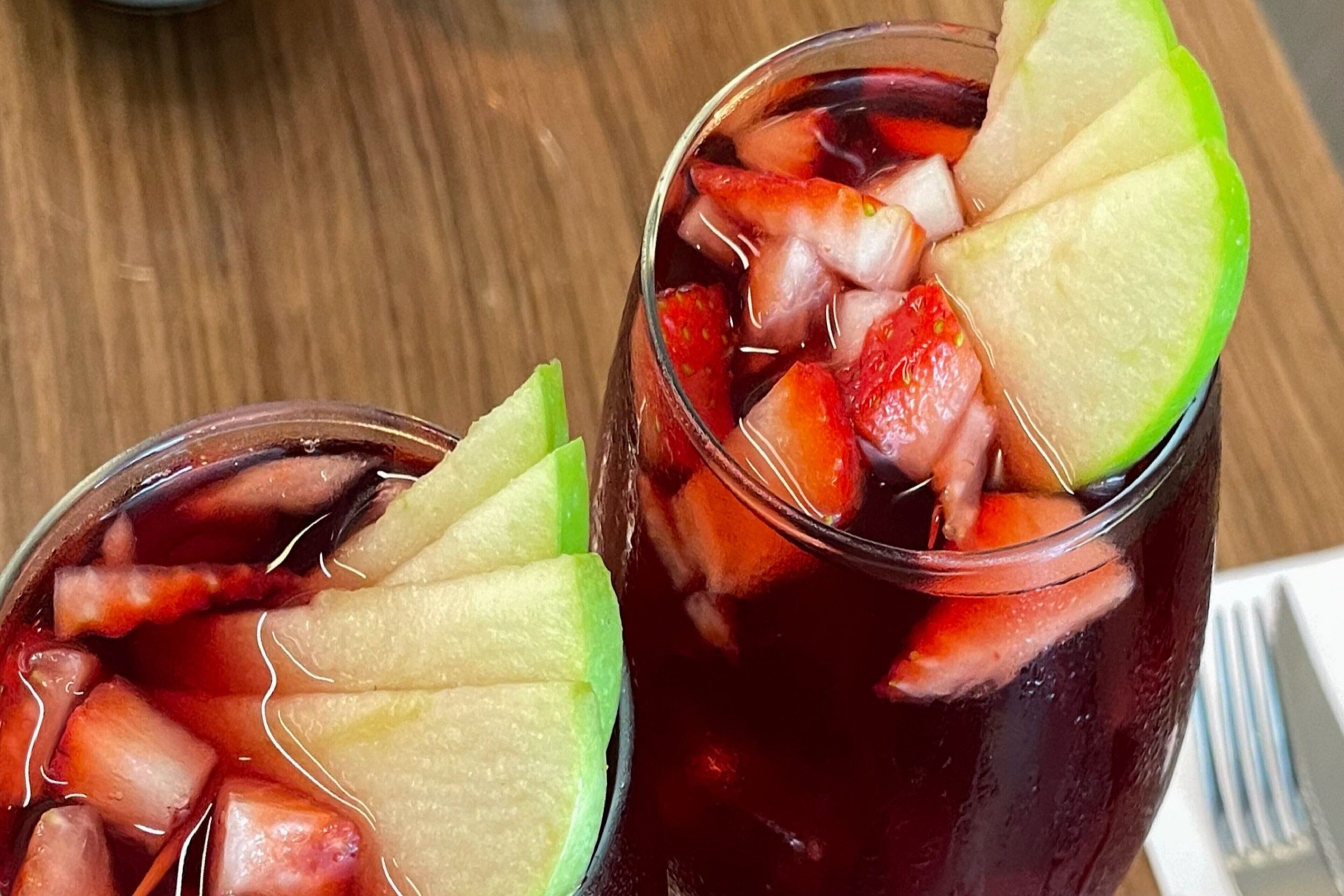 Twee glazen verfrissend drankje met stukjes fruit.