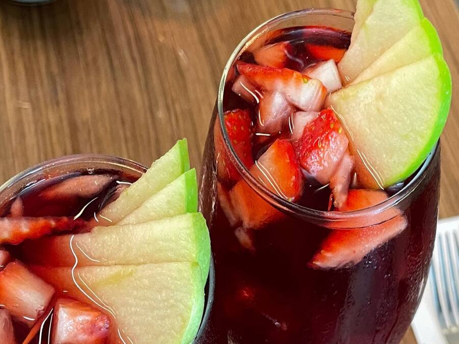 Twee glazen verfrissend drankje met stukjes fruit.
