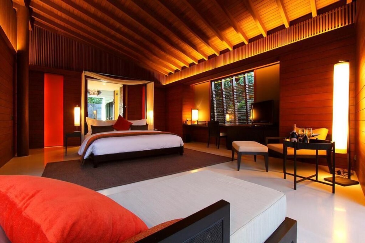 A modern hotel room with a large bed, a desk, and a TV.
