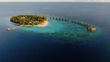 Une île dotée d’une jetée menant à des bungalows sur pilotis.