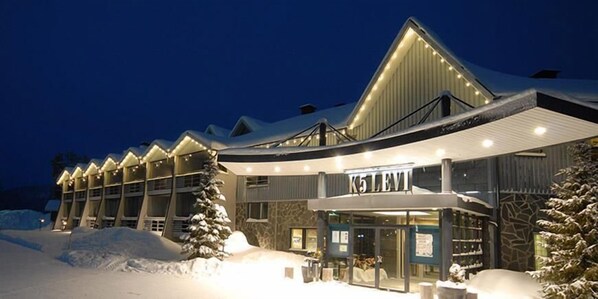 A hotel with a modern design, featuring a large entrance and multiple windows.