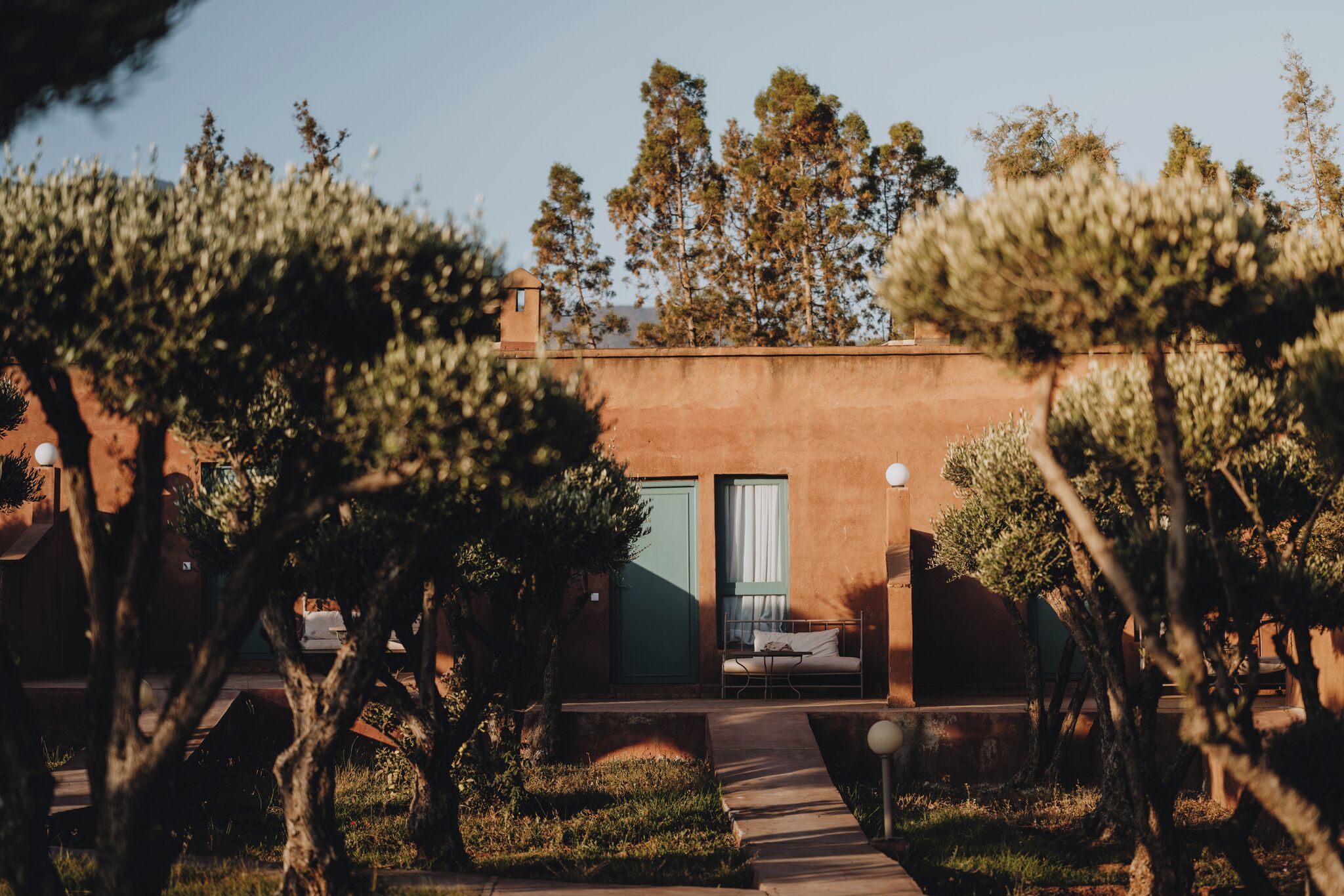 Un bâtiment avec une porte verte, un lit et une fenêtre.
