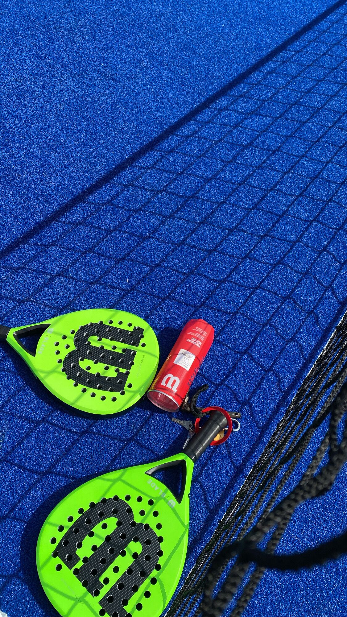 A blue textured surface with two green objects and a red can.