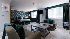 Uma sala de estar moderna com sofá, mesa de centro, cama e televisão.