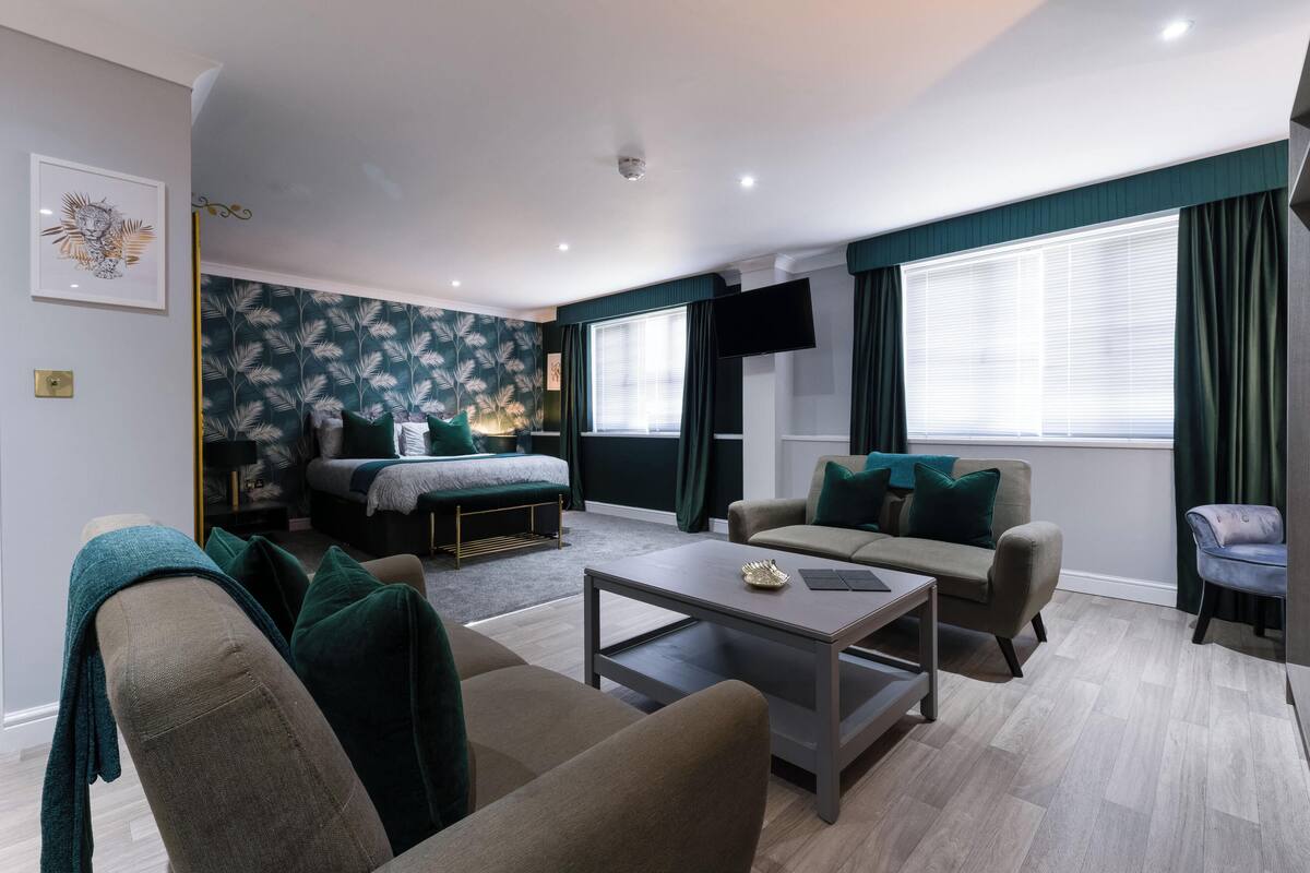 A modern living room with a sofa, a coffee table, a bed, and a TV.