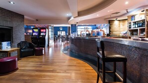 Uma área de bar com balcão, banquetes e um espaço de estar com lareira.