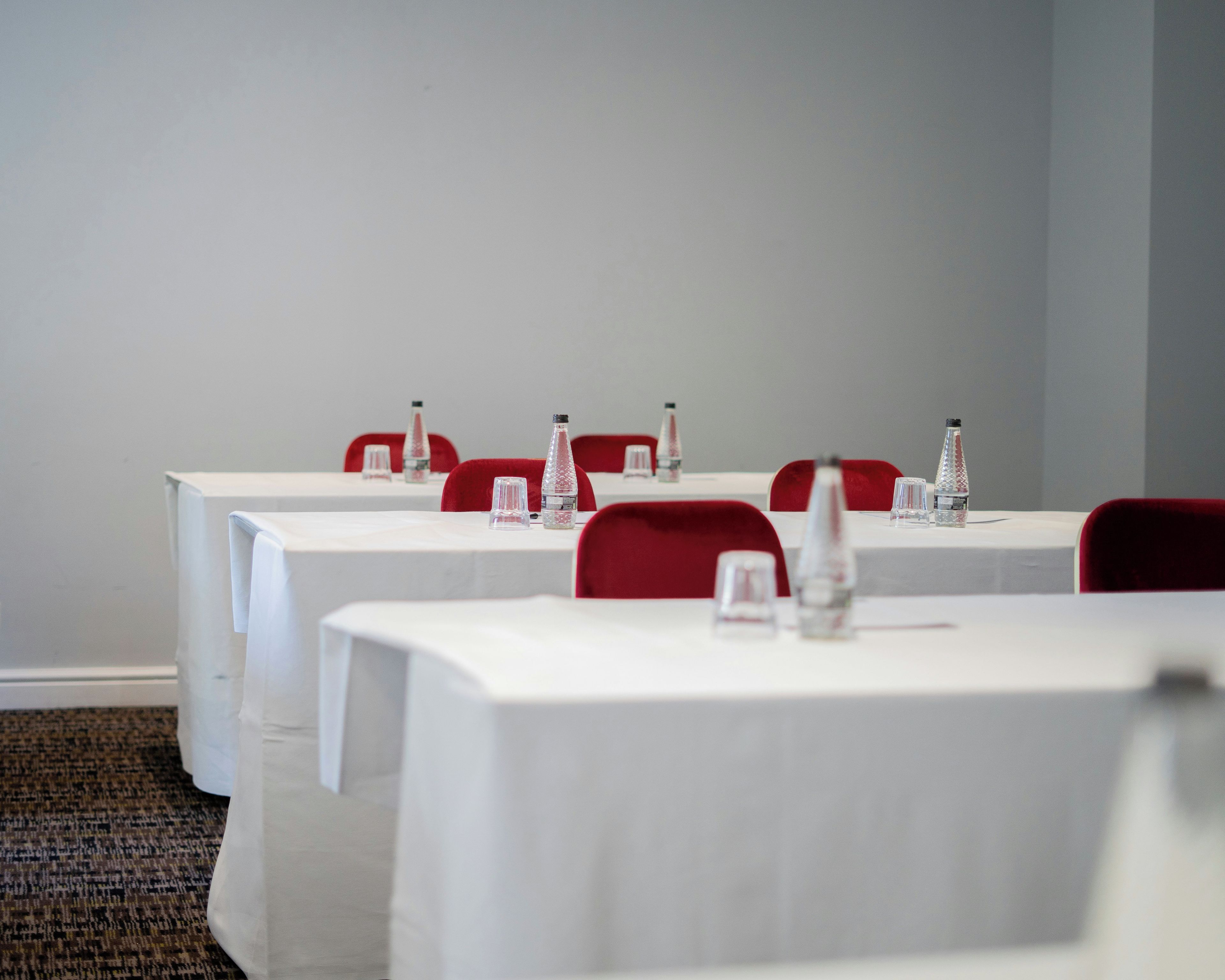 A conference room with tables and chairs, water bottles, and nameplates.