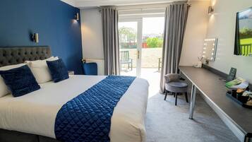 A hotel room with a bed, a desk, and a chair.