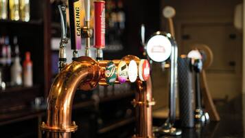 A copper beer tap with multiple spouts, each labeled with different beer brands.