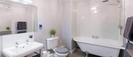 Un baño moderno con lavamanos, inodoro, bañera y ducha.