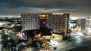 Ein mehrstöckiges Hotel mit zentralem Atrium, einem Parkplatz und Blick auf die Stadtlandschaft.