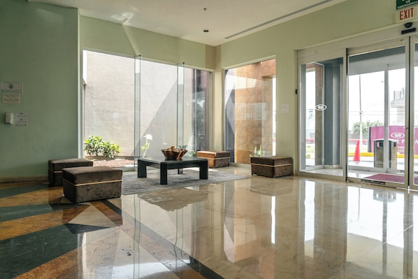 A lobby with a polished floor, seating area, and large windows.