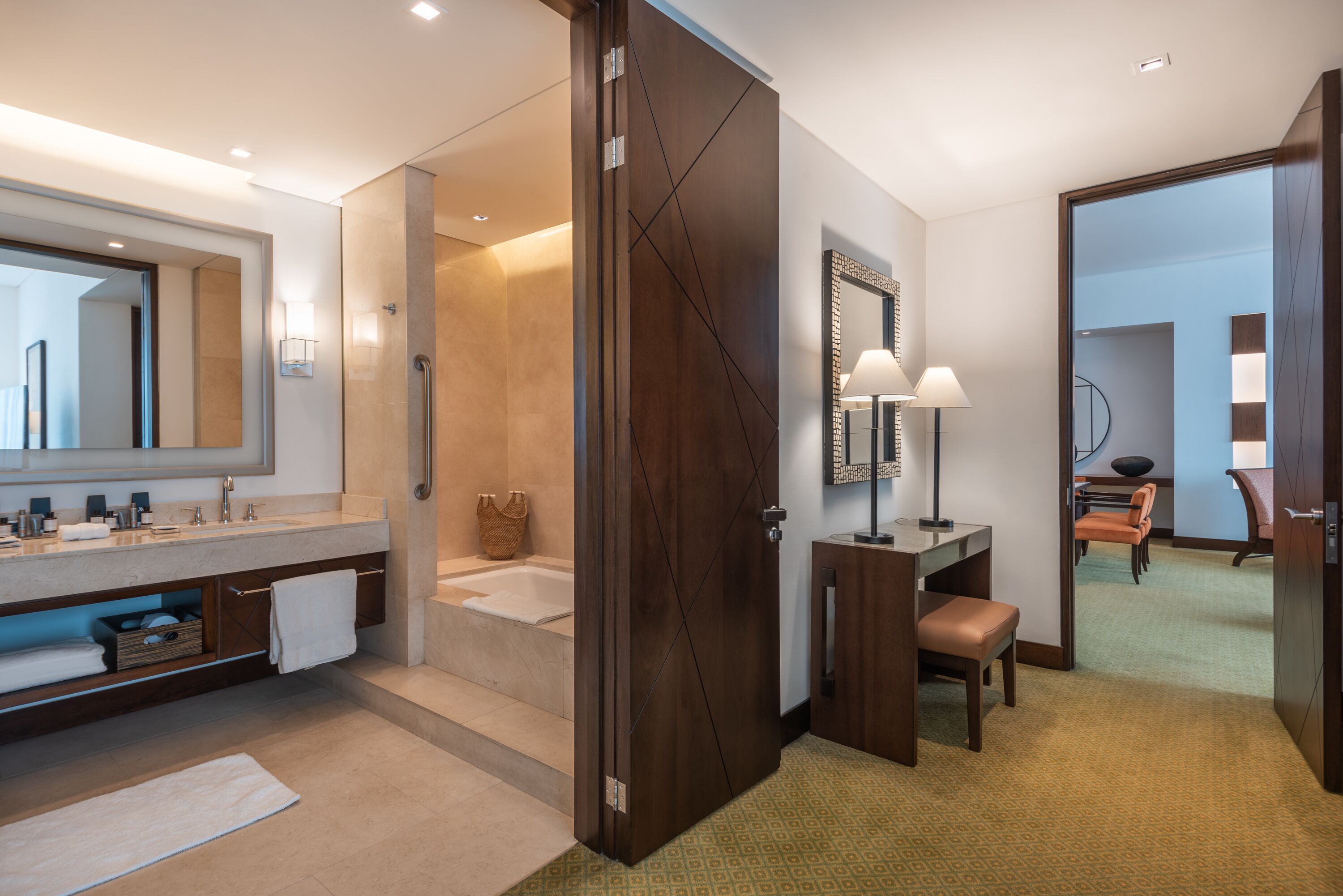 Un baño moderno con un espejo grande, una bañera y un tocador con lavamanos.