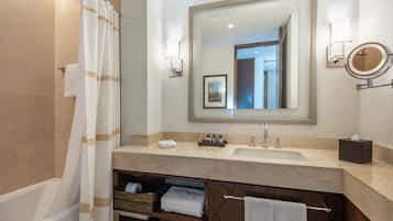 Une salle de bain moderne avec une baignoire, un grand miroir, un lavabo et un meuble-lavabo avec espace de rangement.