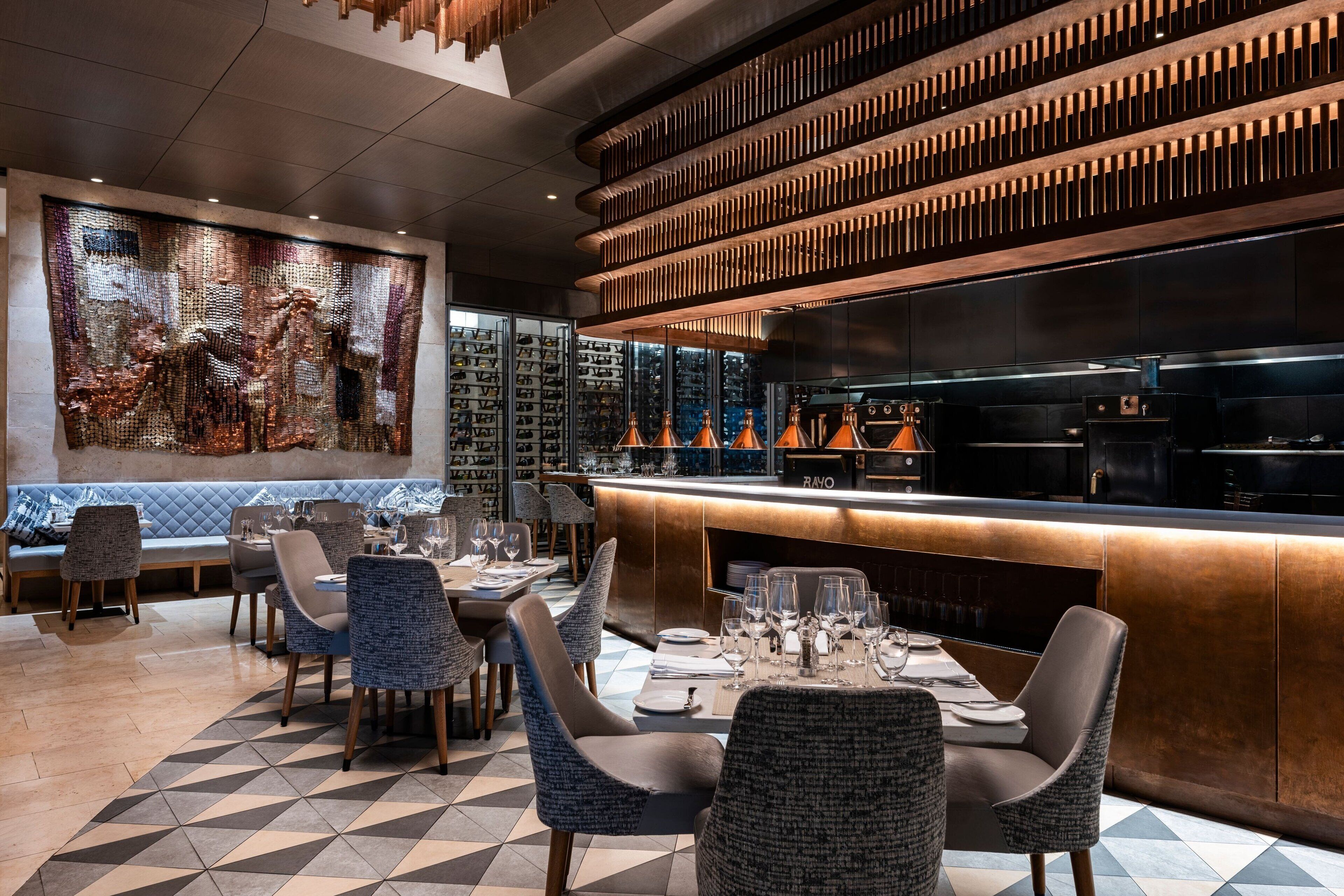 Un intérieur de restaurant moderne avec un bar, des tables et des chaises.