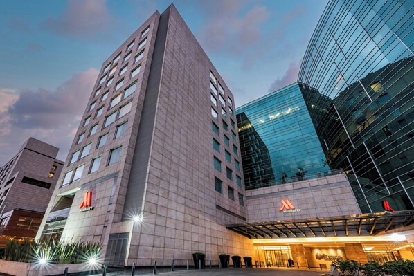 Een modern hotel met een opvallend Marriott logo, grote glasramen en een goed verlicht entreegebied.