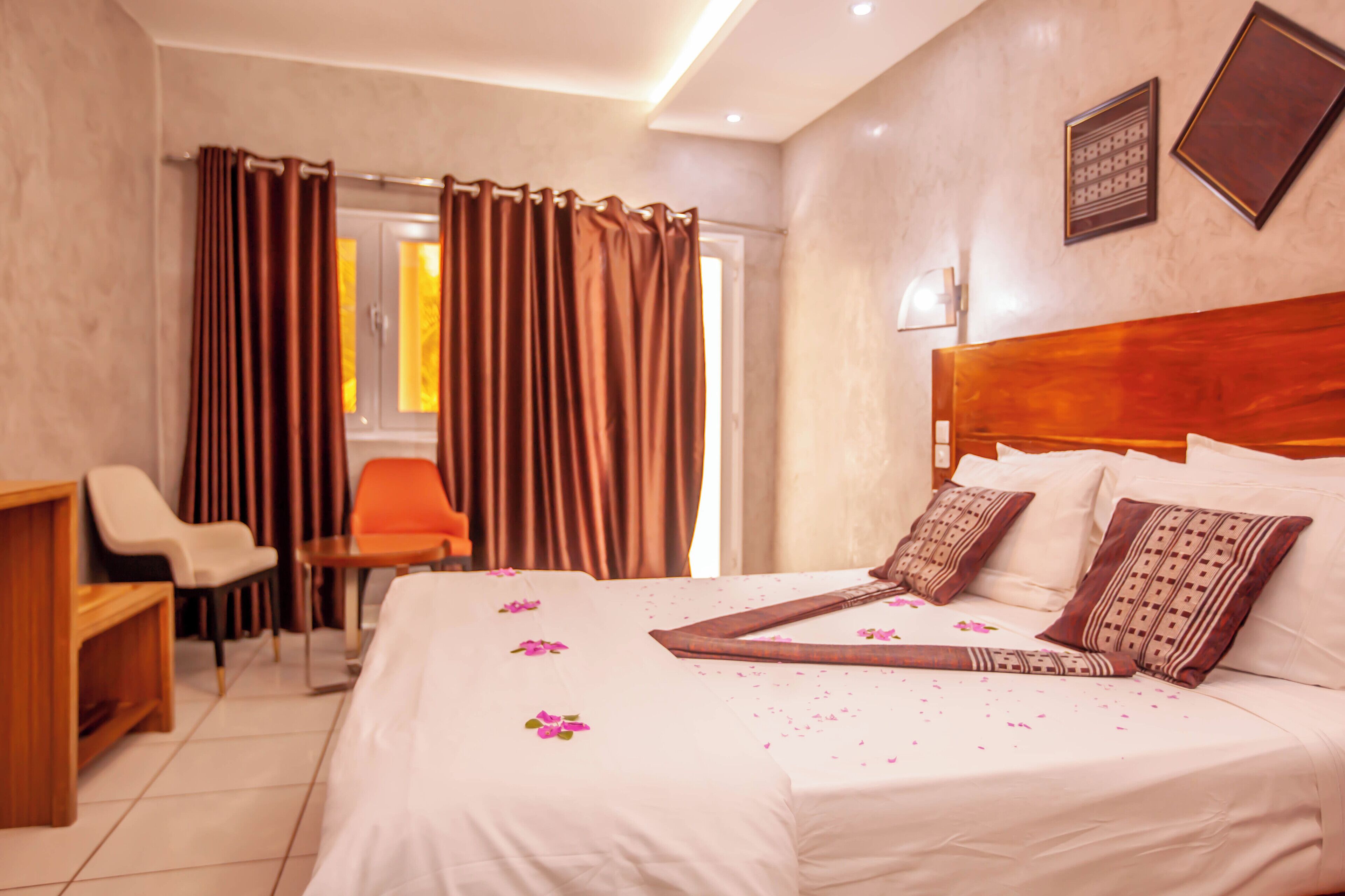 Ein Hotelzimmer mit einem großen Bett, einem Holzkopfende, einem Schreibtisch und einem Stuhl.