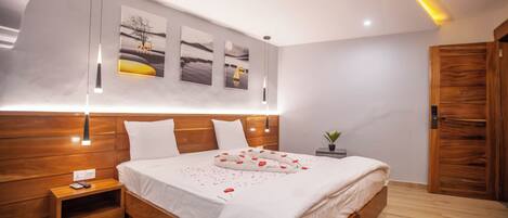 A modern bedroom with a wooden bed, bedside tables, and a nightstand.