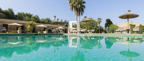 Una piscina cubierta, una piscina al aire libre, tumbonas