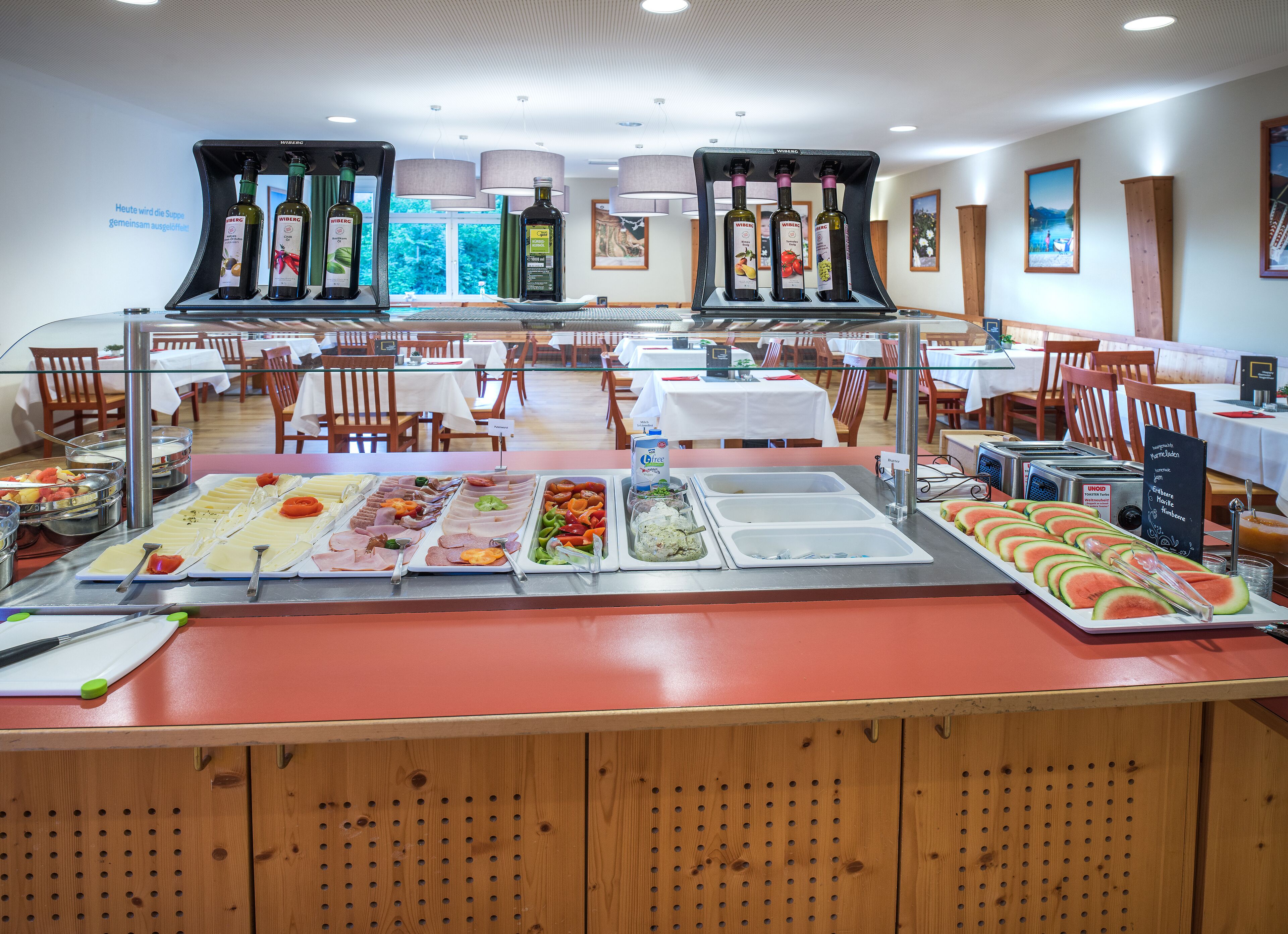 A buffet setup with various food items and a wine selection.