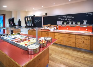 A buffet area with various food options and a coffee station.