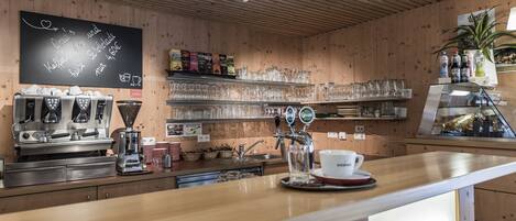 Un café con paredes de madera, una máquina de café y un tablero de menú.